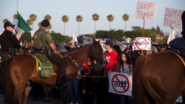 A polícia retém oponentes do trunfo em Costa Mesa, Califórnia, o 28 de abril
